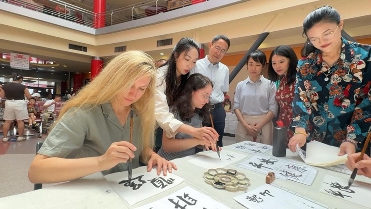 羅馬尼亞友人在活動(dòng)現(xiàn)場(chǎng)學(xué)寫漢字。中國(guó)駐羅馬尼亞大使館領(lǐng)僑處供圖