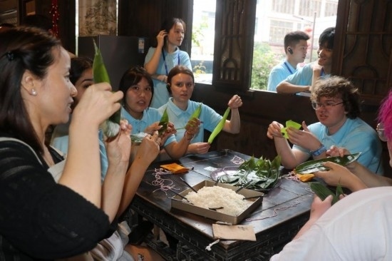 6月9日，美國(guó)青年代表在重慶永川松溉古鎮(zhèn)體驗(yàn)包粽子。新華社記者 周思宇 攝