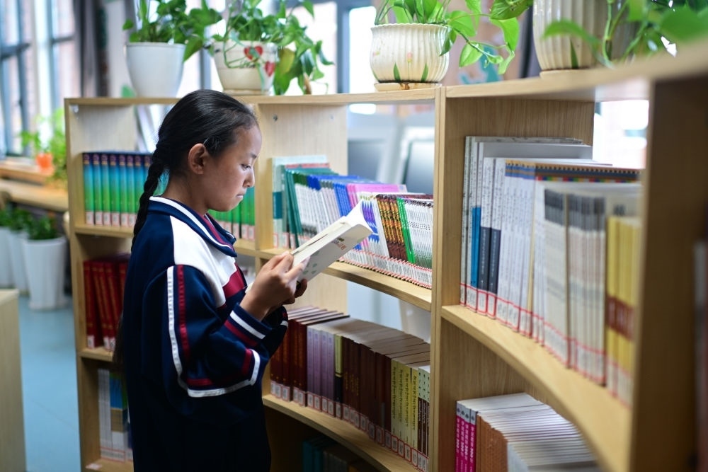 6月18日，果洛西寧民族中學(xué)學(xué)生尼東拉毛在圖書室看書。