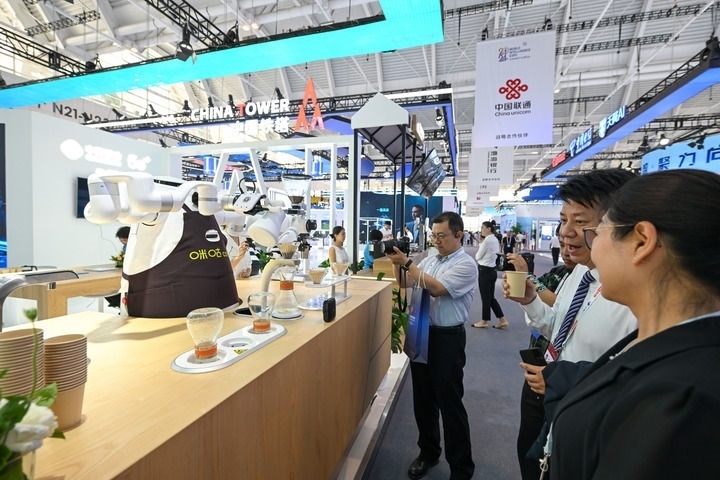 6月20日，與會者品嘗機(jī)器人沖調(diào)出的咖啡。新華社記者 孫凡越 攝