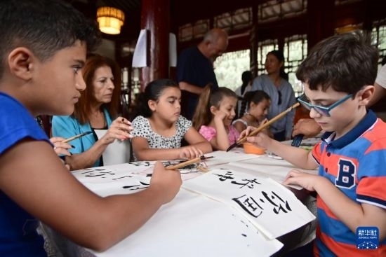 7月4日，在馬耳他桑塔露琪亞市的中國(guó)古典園林“靜園”，人們體驗(yàn)中國(guó)書法。新華社發(fā)（喬納森·博格 攝）