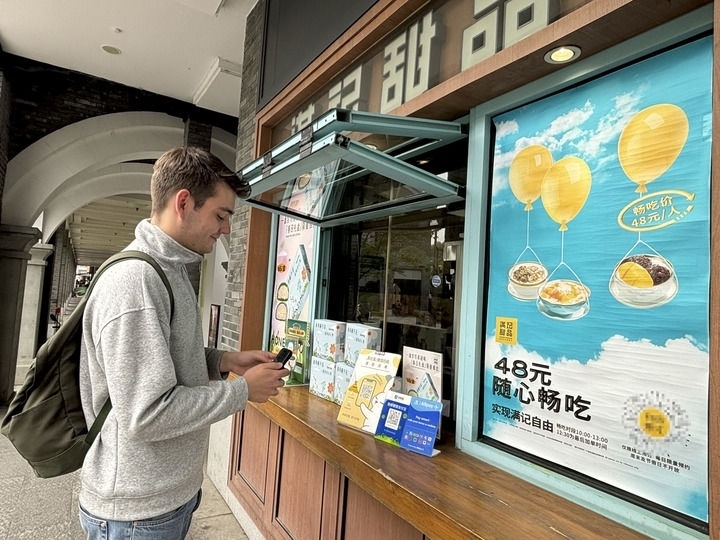 來(lái)自德國(guó)的留學(xué)生理查德在杭州西湖邊一家商鋪使用支付寶掃碼支付（2024年4月11日攝）。新華社發(fā)