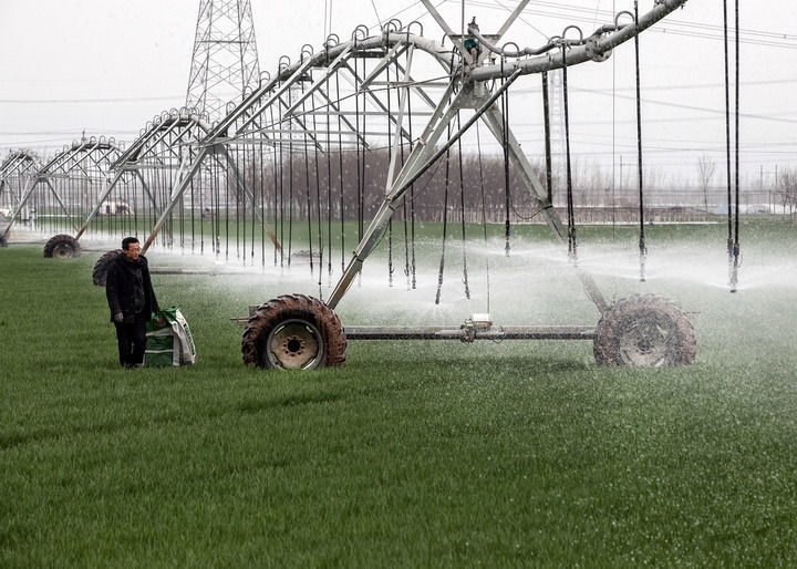 2024年3月18日，在河南省焦作市博愛(ài)縣孝敬鎮(zhèn)東原莊村瑞輝家庭農(nóng)場(chǎng)，村民使用全自動(dòng)指針式噴灌機(jī)進(jìn)行澆灌作業(yè)。新華社發(fā)（程全攝）