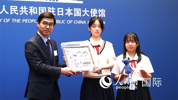 日本小大使向中國駐日本大使館臨時(shí)代辦施泳贈(zèng)送當(dāng)?shù)靥厣Y品。人民網(wǎng) 許可攝