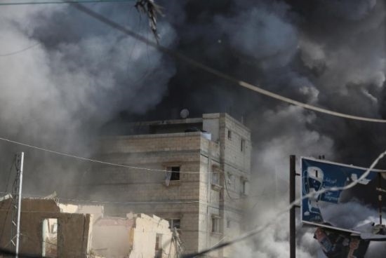 7月21日，在加沙地帶中部的努賽賴特難民營(yíng)，遭以軍空襲的建筑冒出滾滾濃煙。新華社發(fā)（馬爾萬(wàn)·達(dá)烏德攝）