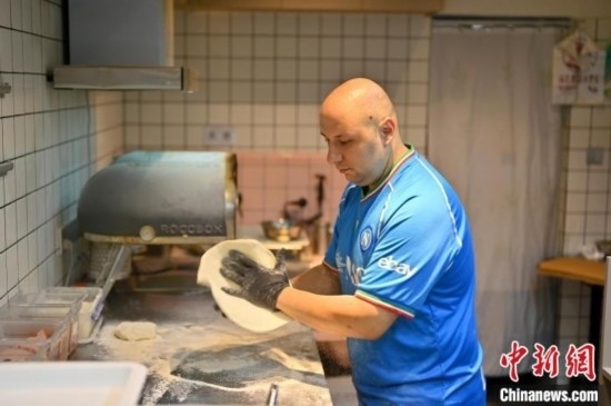 近日，韋榮耀在自家披薩小店內(nèi)忙活。俞靖 攝