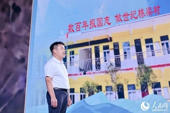 張玉滾分享用一根扁擔(dān)送孩子們走出大山的故事。人民網(wǎng)攝