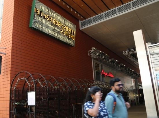 2023年5月29日，人們經(jīng)過美國紐約曼哈頓的“國債鐘”?！皣鴤姟笔且粋€大型計數(shù)器，它實時更新美國的公共債務(wù)總額，并顯示出每個美國家庭所要負(fù)擔(dān)的數(shù)額。 新華社記者劉亞南攝