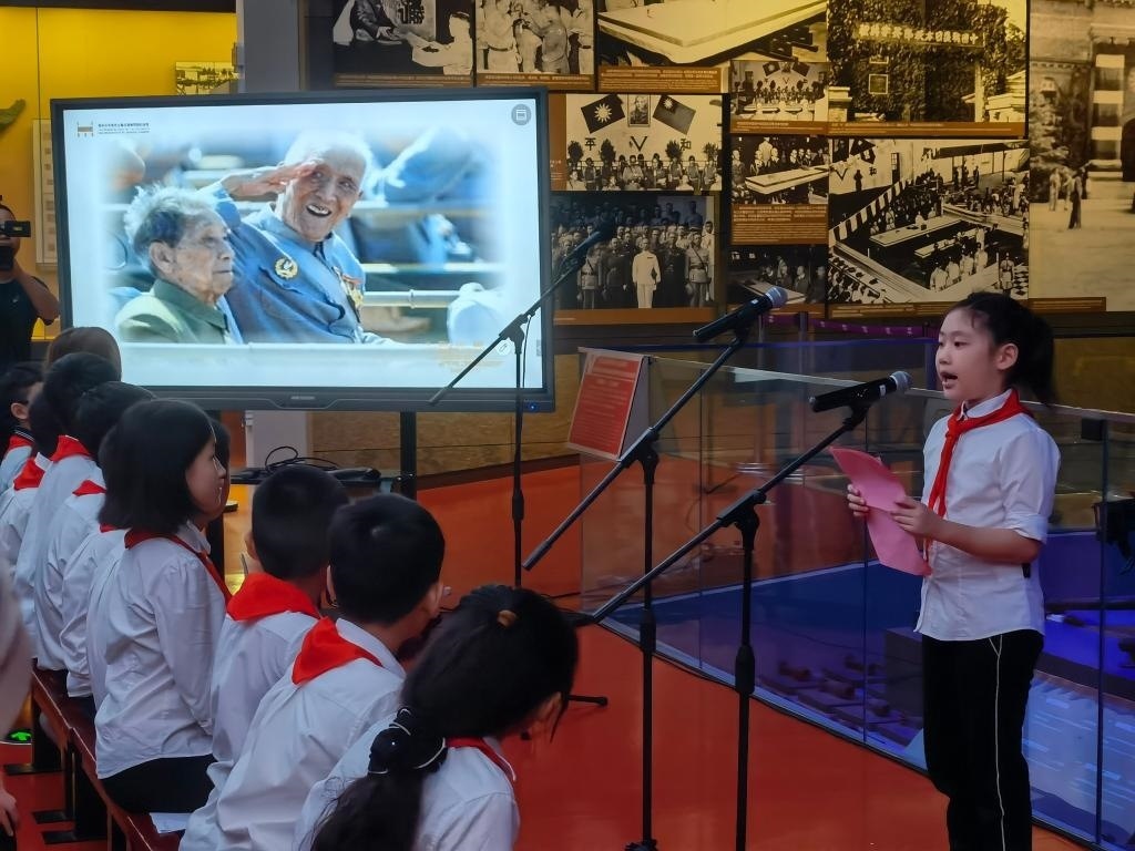 南京市科睿小學(xué)二年級學(xué)生章若初為大家講述抗戰(zhàn)老兵手印的故事。 新華社記者 邱冰清 攝