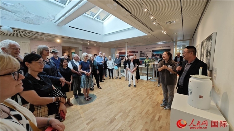 參展人、景德鎮(zhèn)陶瓷大學(xué)美術(shù)學(xué)院副院長(zhǎng)邵長(zhǎng)宗（右一）向來賓介紹參展作品。人民網(wǎng)記者 殷淼攝