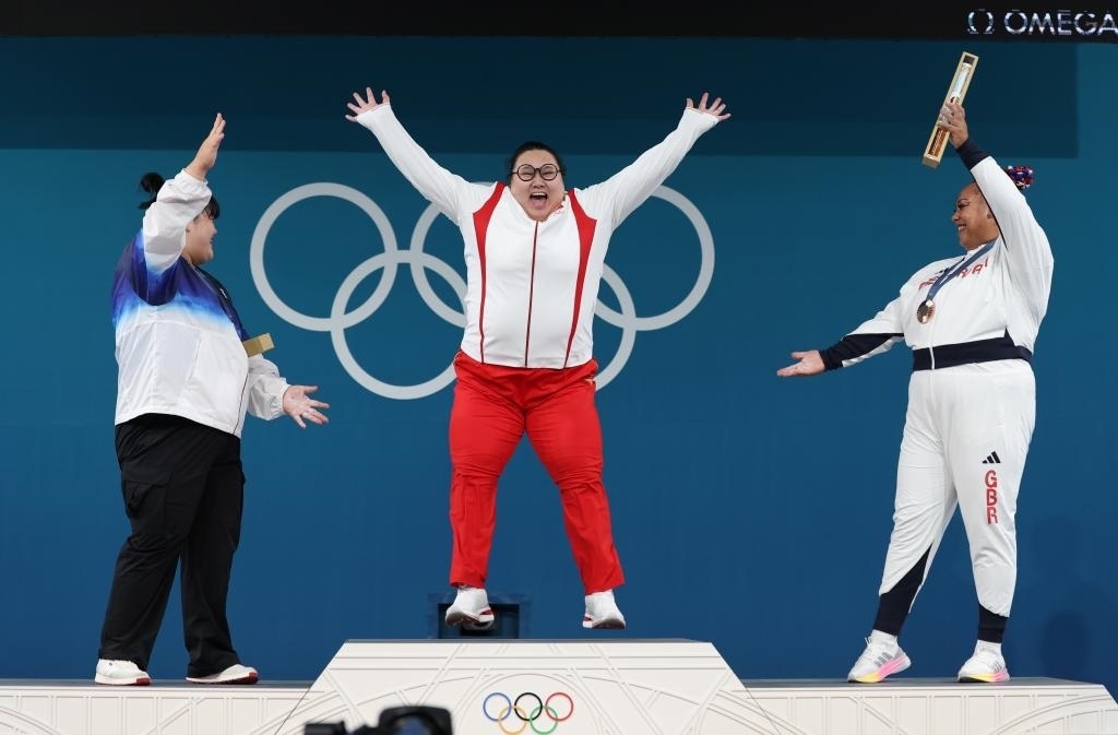 中國選手李雯雯（中）在巴黎奧運(yùn)會舉重女子81公斤以上級頒獎儀式中登上領(lǐng)獎臺（2024年8月11日攝）。新華社記者 楊磊 攝