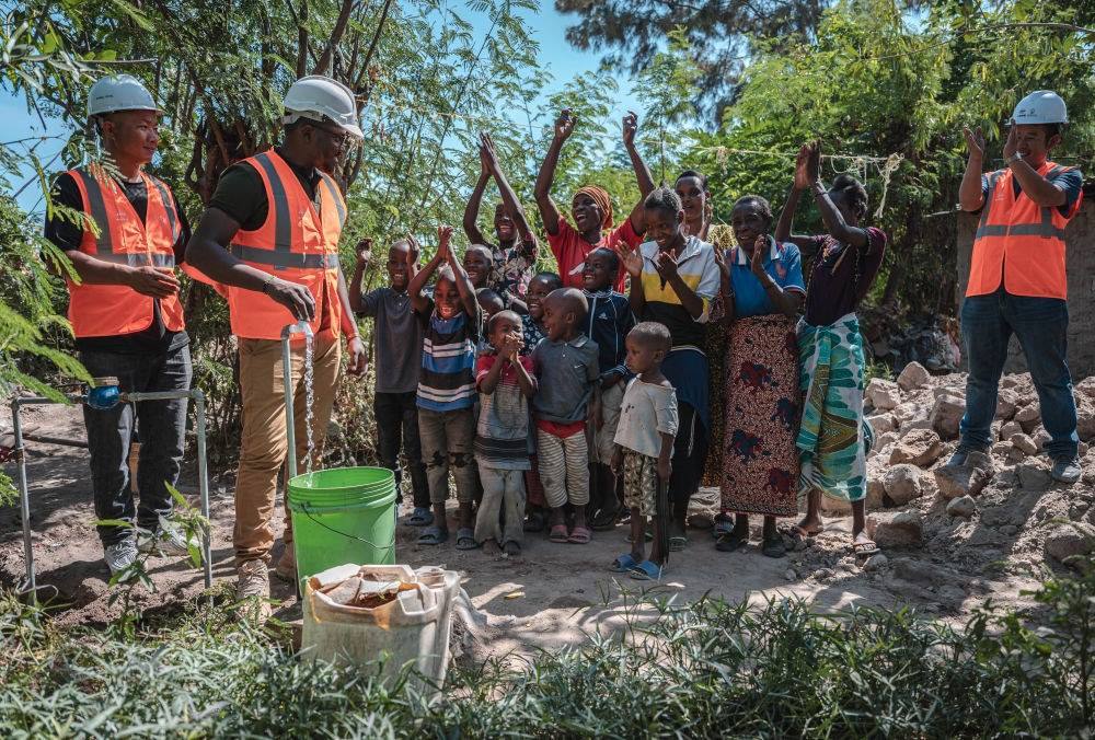 2023年6月13日，在坦桑尼亞姆萬扎省米松圭，工作人員接通水管后贏得當地居民鼓掌歡呼。新華社記者 王冠森 攝
