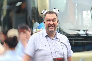 參訪熊貓谷前，塞爾維亞“一帶一路”研究所所長博揚(yáng)·拉利奇戴上熊貓頭飾。（李佩藺 攝）