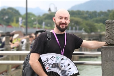 俄羅斯塔斯社執(zhí)行編輯葉夫根尼·扎多羅日內在都江堰魚嘴拍照留念。（李佩藺 攝）