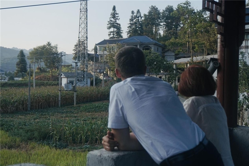 望得見山，看得見水，記得住鄉(xiāng)愁。每個人心中都有一個屬于自己的“花茂村”，在這方心田，走遍千山萬水，鄉(xiāng)音未改鬢毛衰。吉爾吉斯斯坦《比什凱克晚報》第一副總編輯妮娜·尼奇博洛娃與《中國與俄羅斯》雜志社社長奧列格·別列日內(nèi)赫攝在花茂村民居屋檐下并肩佇立，眺望山水，尋覓鄉(xiāng)愁。（李光裕攝）