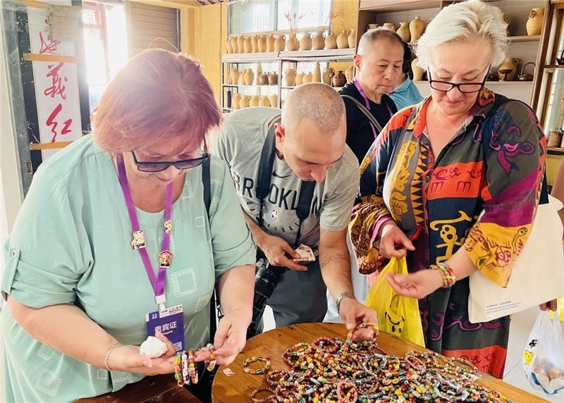 歐亞媒體考察團(tuán)成員在母氏陶藝館內(nèi)挑花了眼，色彩絢麗、質(zhì)地均勻的陶藝手串讓他們愛不釋手?！斑@里的東西都太實惠了！”塔吉克斯坦《索格特真理報》政論部主任娜塔利婭·多羅費(fèi)耶娃說。花茂村的特色產(chǎn)品物美價廉，讓考察團(tuán)成員為家人好友買到了心儀的禮物，也為此次以四川成都為起點，路經(jīng)南充、廣安至貴州遵義的考察行程畫上了圓滿句號。（張亞欣攝）