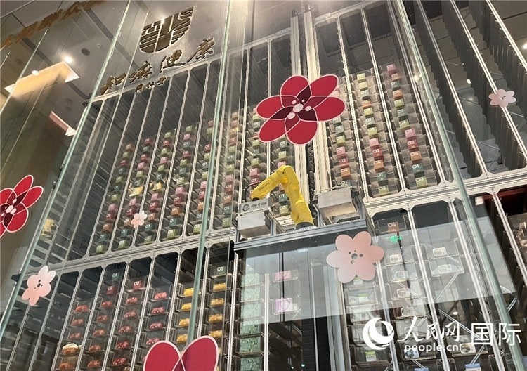 6. 機(jī)械臂正在取貨。（人民網(wǎng)記者陳思 攝）