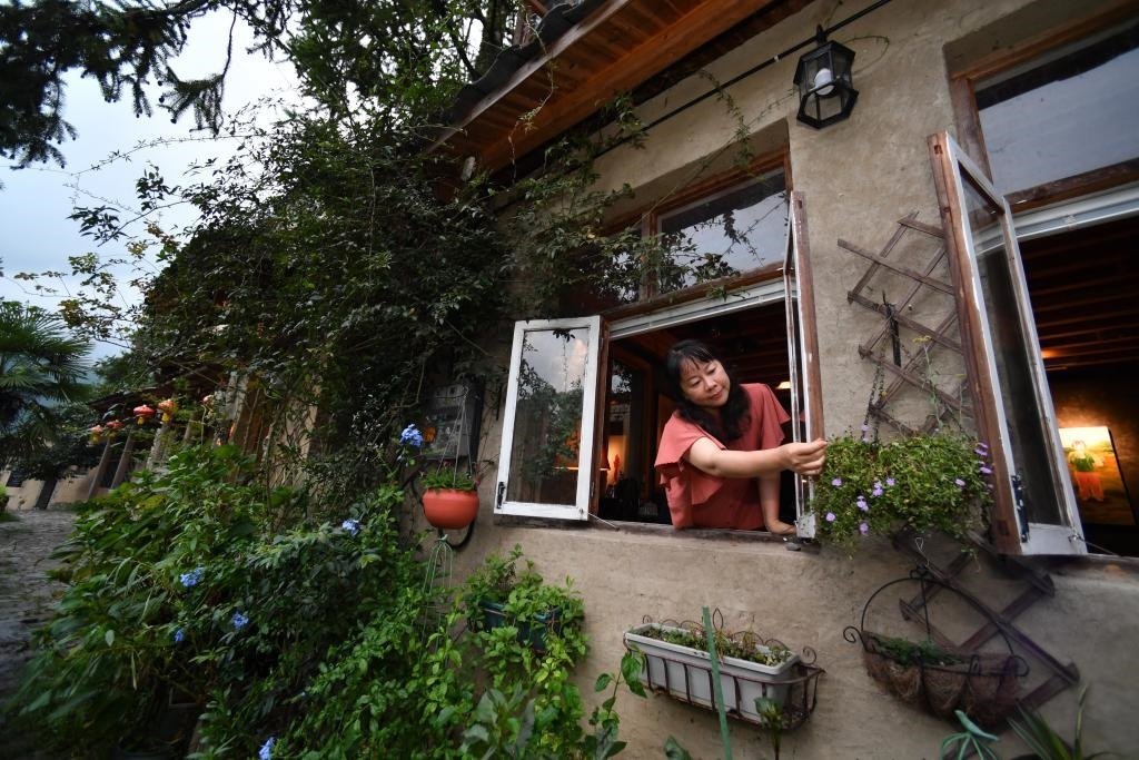 8月29日，在福建省屏南縣熙嶺鄉(xiāng)，龍?zhí)洞濉靶麓迕瘛泵泛暝诖蚶碜约航?jīng)營(yíng)的民宿外墻裝飾花盆。新華社記者姜克紅 攝