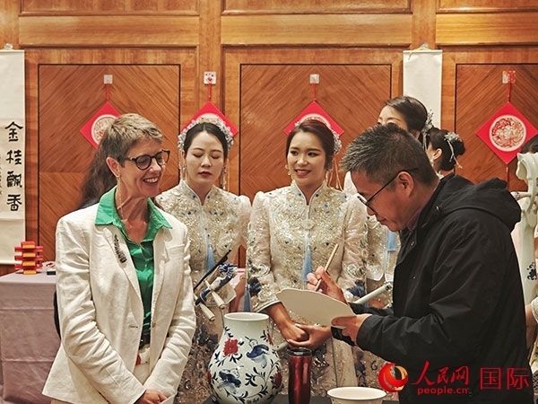 現(xiàn)場(chǎng)的非遺傳承人為英國(guó)觀眾展示畫技。人民網(wǎng)記者 邢雪攝