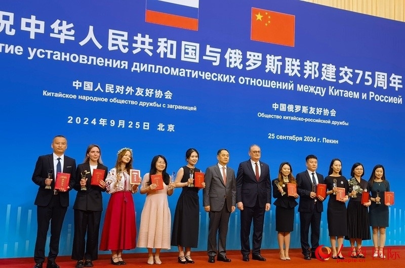 楊萬(wàn)明會(huì)長(zhǎng)和莫爾古洛夫大使為10位中俄青年友好微視頻創(chuàng)意大賽獲獎(jiǎng)代表頒獎(jiǎng)。人民網(wǎng)記者 李明琪攝