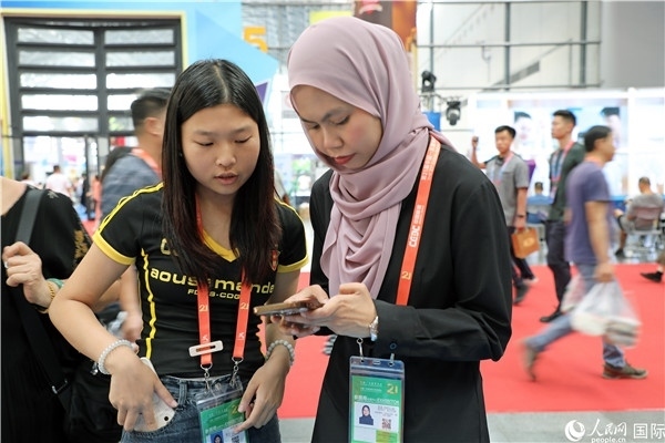 東博會現(xiàn)場，馬來西亞展商在同中方工作人員交談。人民網(wǎng)記者 趙益普攝