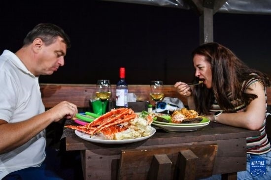 9月2日，食客們在俄羅斯符拉迪沃斯托克的一家餐館品嘗帝王蟹。新華社記者 曹陽 攝