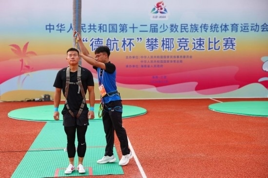 11月23日，工作人員為上海隊(duì)選手付樂樂（左）系安全繩。新華社記者 楊植森 攝