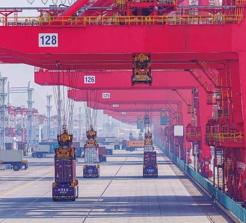 共建“一帶一路”國(guó)家在工作制度對(duì)接、技術(shù)標(biāo)準(zhǔn)協(xié)調(diào)、檢驗(yàn)結(jié)果互認(rèn)等方面強(qiáng)化合作、統(tǒng)一標(biāo)準(zhǔn)，貿(mào)易自由化便利化水平不斷提升。上海洋山港海關(guān)對(duì)接共建國(guó)家進(jìn)出口貨物相關(guān)標(biāo)準(zhǔn)，推動(dòng)通關(guān)一體化方式申報(bào)，提升通關(guān)效率。圖為無人駕駛的全自動(dòng)導(dǎo)引車在洋山港穿梭往來，搬運(yùn)集裝箱。王初 攝