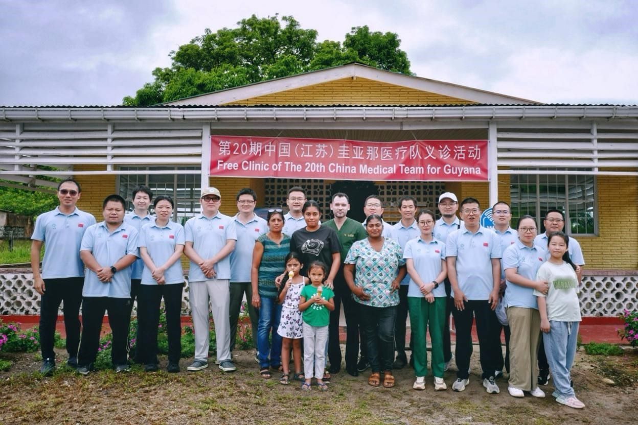 第20期中國（江蘇）援圭亞那醫(yī)療隊在圭偏遠(yuǎn)的林登高速社區(qū)開展義診后，與部分當(dāng)?shù)鼐用窈嫌啊?中國援圭醫(yī)療隊供圖