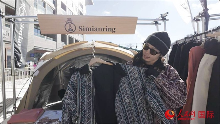 藤田周正在展示自己設(shè)計(jì)的滑雪服。人民網(wǎng)記者 袁蒙攝