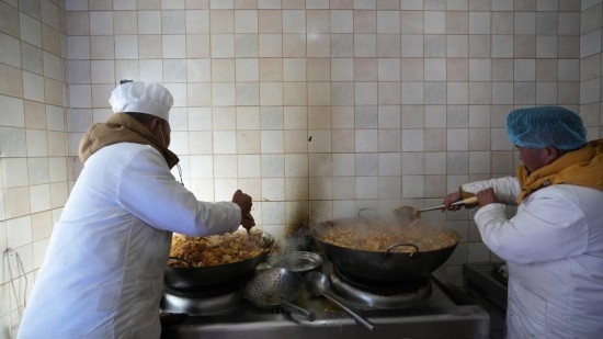 1月14日，服務(wù)隊(duì)的兩名廚師正在為村民們做午飯。新華社記者 邱星翔 攝
