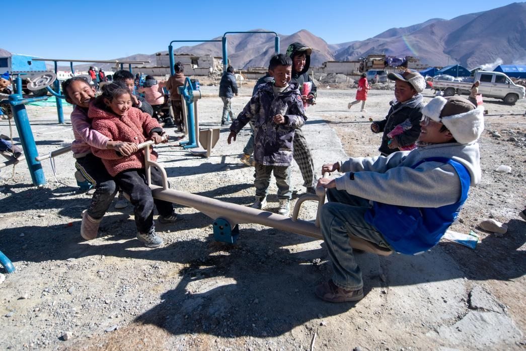 1月11日，在定日縣措果鄉(xiāng)塘仁村安置點(diǎn)，西藏星光社會(huì)工作服務(wù)中心志愿者和孩子們一起玩耍，進(jìn)行災(zāi)后心理疏導(dǎo)。人民網(wǎng)記者 翁奇羽攝