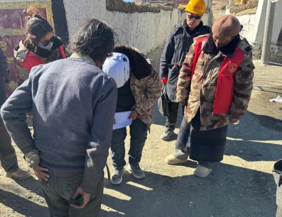 1月13日，次旺（右一）陪同工作組走訪村莊，評估房屋受損程度。新華社發(fā)