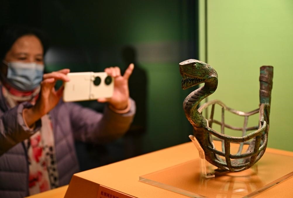 1月14日，觀眾在上海博物館蛇年迎春展拍攝展品蛇綱網(wǎng)狀銅器。新華社發(fā)（陳浩明攝）