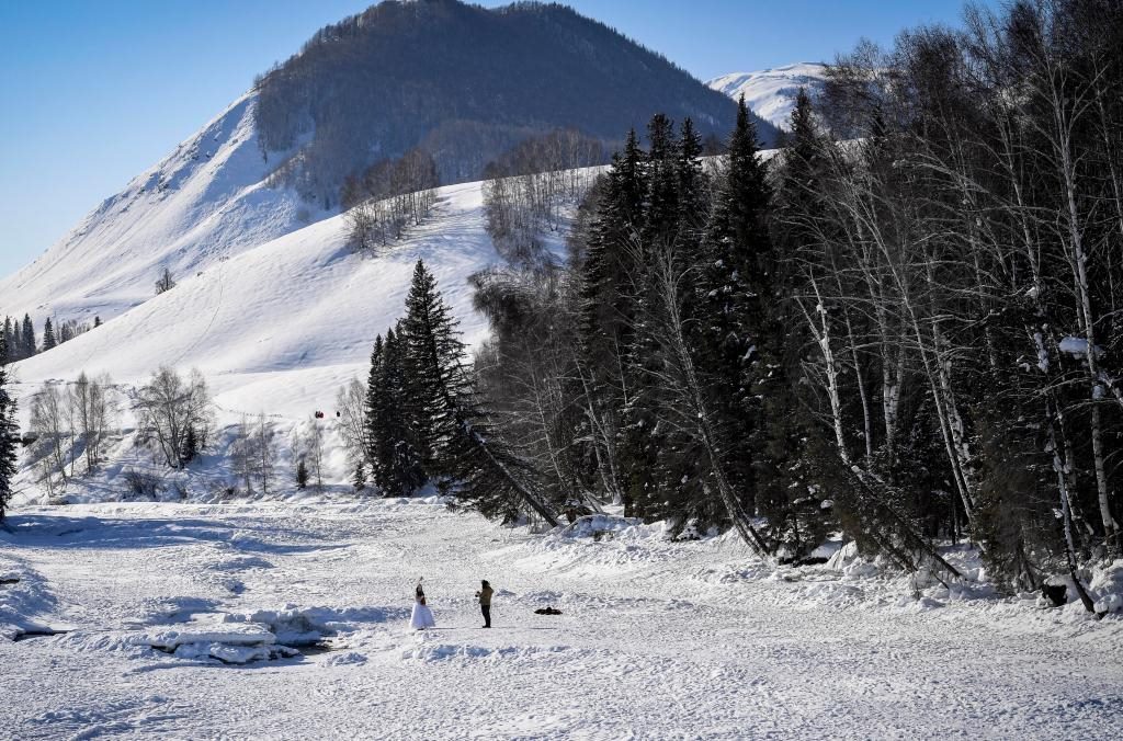 2024年2月5日，兩名游客在新疆阿勒泰地區(qū)布爾津縣禾木村拍照。新華社記者 馬鍇 攝