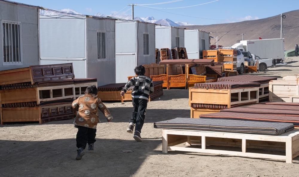 2025年1月13日，在定日縣嘎旦村，兩個孩子在剛運來的兩排藏床間奔跑。新華社記者丁增尼達 攝