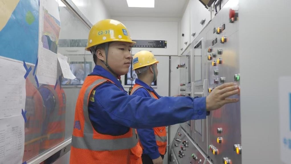 盾構(gòu)司機(jī)何曉波在駕駛室內(nèi)調(diào)試盾構(gòu)機(jī)參數(shù)。（劉芬攝）