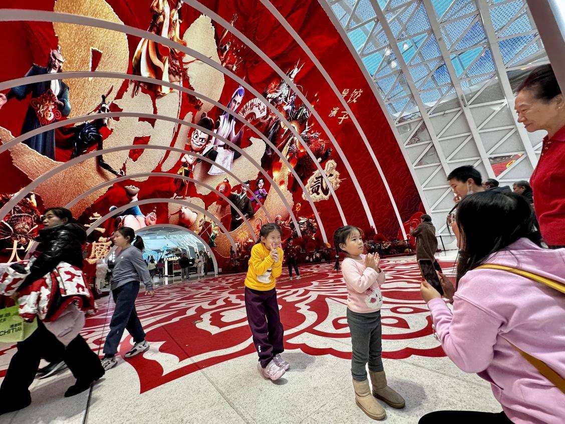 乙巳蛇年春節(jié)期間，影迷在《哪吒之魔童鬧?！肪薹?bào)前拍照打卡。