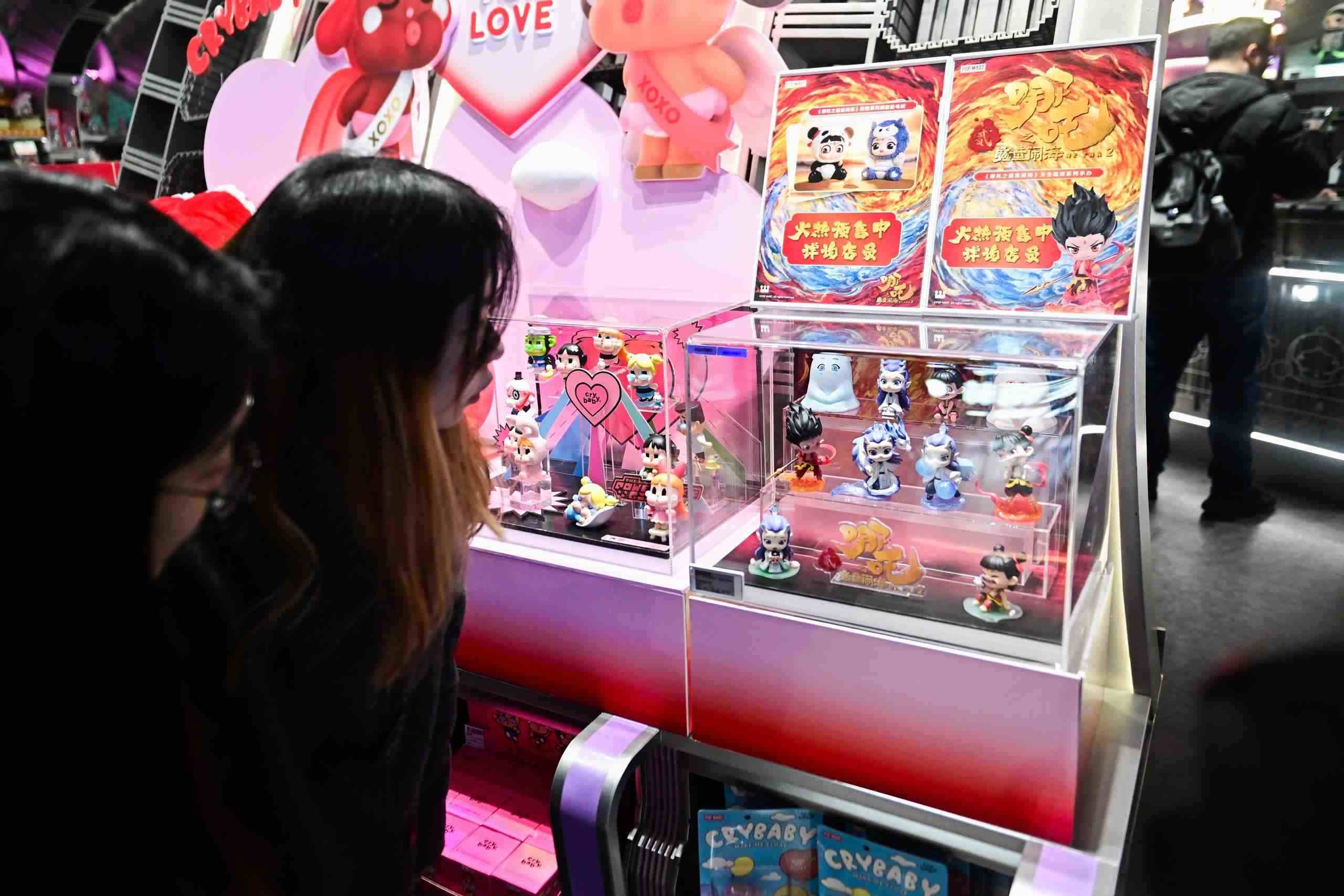 △2025年2月22日，上海，市民在圍觀《哪吒之魔童鬧?！废嚓P(guān)手辦盲盒。