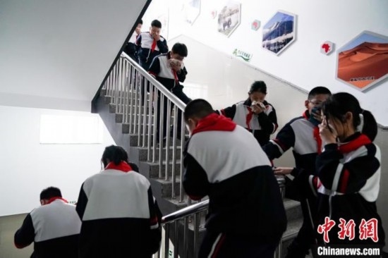  圖為學(xué)生們進(jìn)行應(yīng)急疏散演練。中新社記者 趙宇航 攝