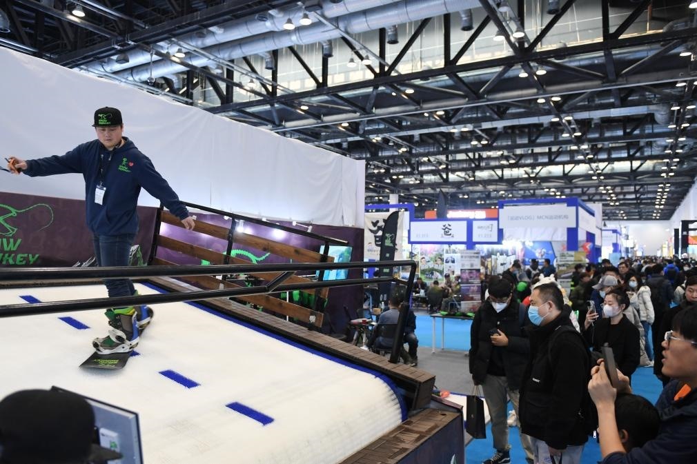 2023年2月11日，參觀者在展會(huì)上了解一款模擬滑雪設(shè)備。當(dāng)日，2023亞洲運(yùn)動(dòng)用品與時(shí)尚展在國家會(huì)議中心拉開帷幕。新華社記者 張晨霖 攝