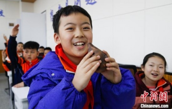 圖為學(xué)生在“國(guó)寶音樂(lè)會(huì)”社教課中體驗(yàn)吹陶塤。中新社記者 馬銘言 攝