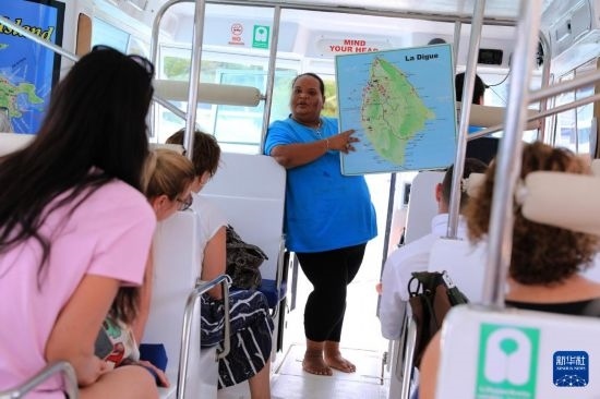 3月15日，一名導(dǎo)游在游艇上為游客介紹塞舌爾拉迪格島。新華社記者 董江輝 攝