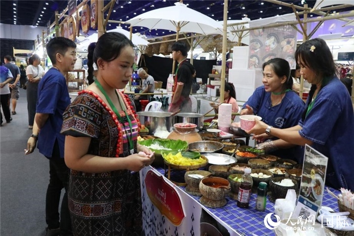 游客在攤位前購(gòu)買特色美食。朱瀟逸攝
