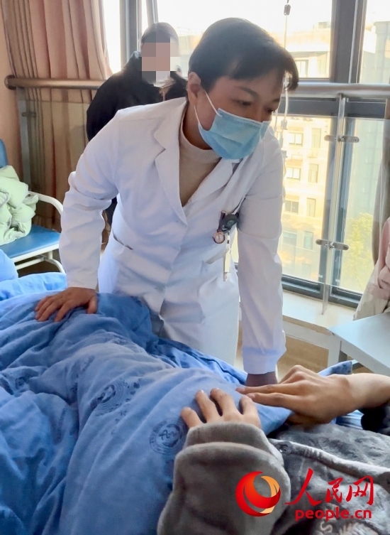 鄧茜查房時詢問患者情況。人民網(wǎng)記者 金慧慧攝