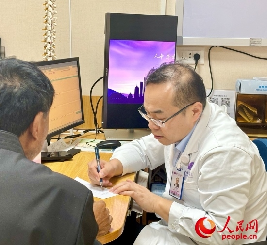 路桂軍接診時為患者寫下用藥提示。人民網(wǎng)記者 金慧慧攝