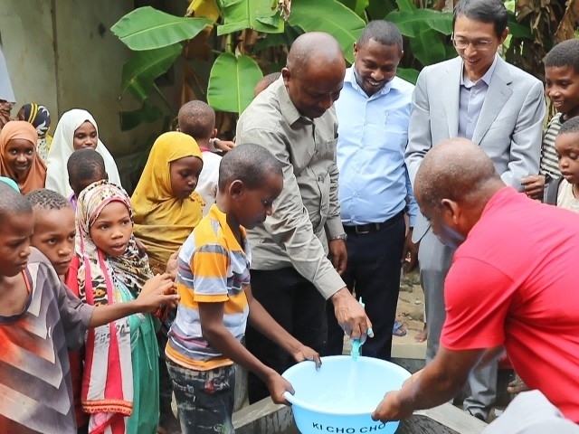 在日前舉行的安全供水工程揭牌儀式上，當(dāng)?shù)匦∨笥言诠┧c(diǎn)接水。 施亮攝