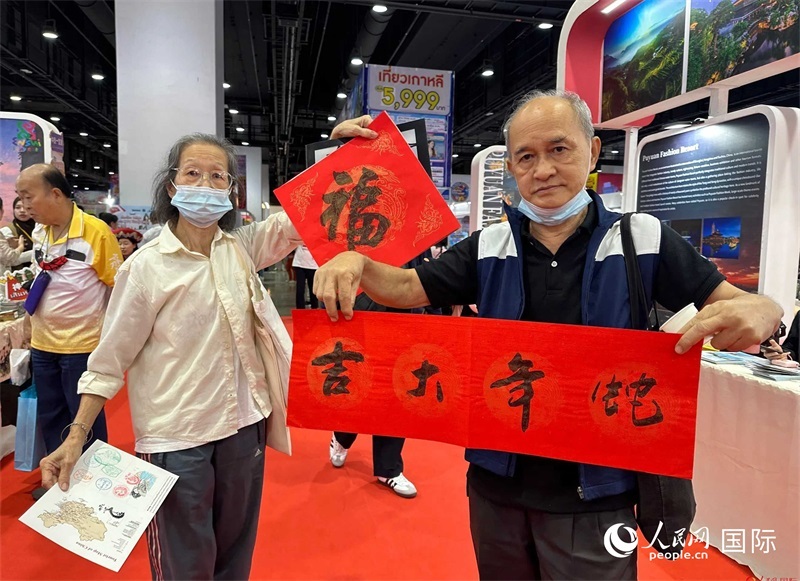 2025蛇年春節(jié)，泰國市民展示他們領(lǐng)到的華人手寫春聯(lián)。人民網(wǎng)記者 簡承淵攝