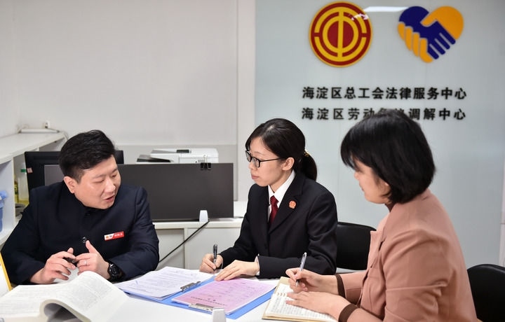 2025年3月6日，在北京市海淀區(qū)總工會勞動爭議調(diào)解中心，海淀區(qū)人民法院法官王琰（中）與該中心工作人員就糾紛化解情況進(jìn)行溝通。新華社記者 趙婷婷 攝