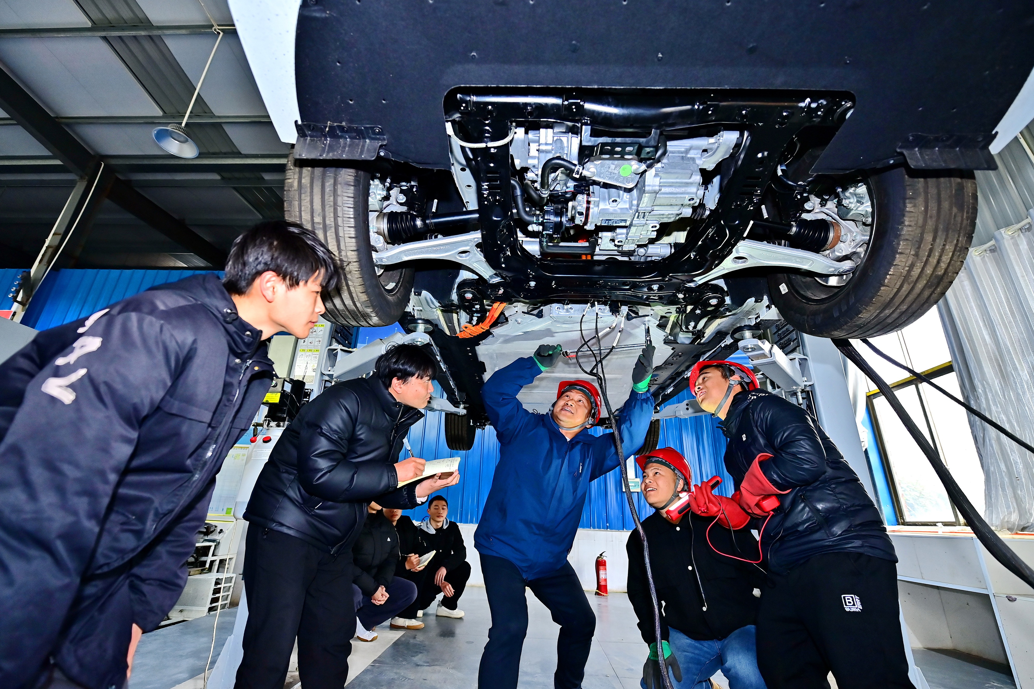 2025年2月，江西省宜春市，豐城市的一所技工學(xué)校實(shí)訓(xùn)基地內(nèi)，新能源汽車運(yùn)維專業(yè)學(xué)生在老師的指導(dǎo)下學(xué)習(xí)新能源汽車電池包檢修技術(shù)。